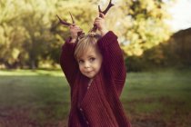 Toddler using sticks as antlers — Stock Photo