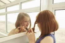 Menina entranhando cabelo no alpendre do apartamento de férias — Fotografia de Stock