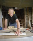 Senior man doing carpentry in workshop — Stock Photo