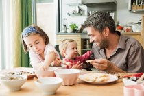 Father and children baking in kitchen — Stock Photo