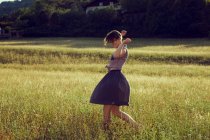 Jovem mulher caminhando pelo prado — Fotografia de Stock