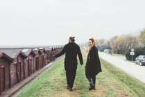 Rear view of couple strolling on embankment — Stock Photo