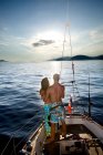 Jeune couple sur voilier regarder coucher de soleil — Photo de stock