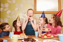 Fille manger de la nourriture de fête avec des amis regarder — Photo de stock