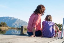 Mother and daughter sitting on deck — Stock Photo