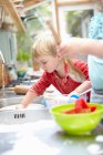 Children washing dishes together — Stock Photo