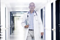 Médico varón caminando por el pasillo - foto de stock