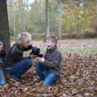 Boys pouring hot drink from flask in forest — Stock Photo