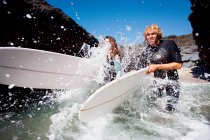 Casal correndo na água com pranchas de surf — Fotografia de Stock