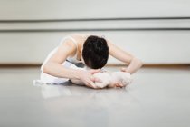 Ballet dancer stretching in studio — Stock Photo