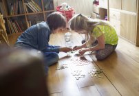 Brother and sister counting coins from savings jar — Stock Photo
