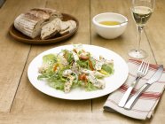 Салат из курицы с столовыми приборами и бокалом шампанского — стоковое фото