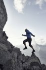 Homme mûr sautant sur les rochers, Valais, Suisse — Photo de stock
