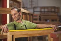 Carpenter measuring frame at carpentry — Stock Photo