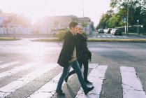 Jeune couple lesbienne marchant à travers la rue de la ville de passage pélican — Photo de stock