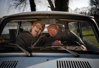 Coppia anziana ridendo in auto — Foto stock