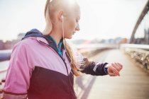 Час перевірки середньої дорослої жінки бігунки на пішохідному мосту — стокове фото