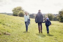 Father and daughters walking in countryside field — Stock Photo