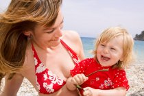 Madre e figlia sorridenti in spiaggia — Foto stock
