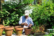 Man potting plants in backyard — Stock Photo