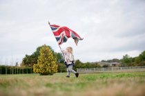 Kleines Mädchen hält Fahne hoch — Stockfoto