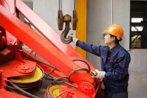 Trabajador que usa equipos en instalaciones de fabricación de grúas, China - foto de stock