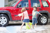 Children playing and washing car — Stock Photo