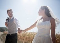 Recién casada pareja caminando al aire libre - foto de stock