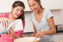 Teenage girls preparing food in kitchen — Stock Photo