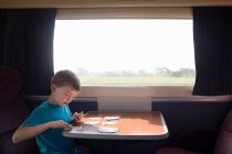 Мальчик с игральными картами в поезде — стоковое фото