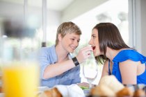 Frau füttert Freundin beim Frühstück — Stockfoto