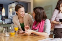 Улыбающиеся женщины разговаривают в кафе — стоковое фото