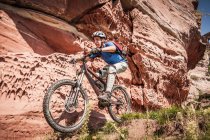 Homem de bicicleta de montanha ao lado de pedras — Fotografia de Stock