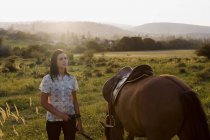 Frau hält Pferd auf der Weide — Stockfoto