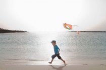 Мальчик летал на воздушном змее на пляже — стоковое фото