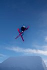 Skieur traversant des skis dans les airs — Photo de stock