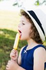 Girl eating popsicle outdoors — Stock Photo