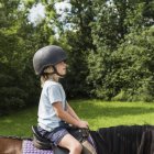 Side view of boy horse riding — Stock Photo