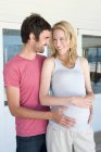 Man holding pregnant girlfriends belly — Stock Photo