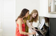 Teenage girls playing piano together — Stock Photo