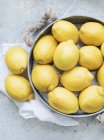 Limones en plato de metal - foto de stock