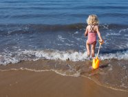 Criança brincando na água na praia — Fotografia de Stock
