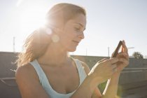Portrait of young woman looking at mobile phone — Stock Photo