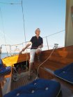 Ältere Frau steuert Segelboot — Stockfoto