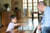 Pai e filho jogando xadrez juntos — Fotografia de Stock