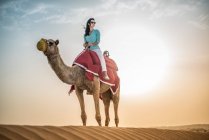 Жіночий туристичних їзда верблюда у пустелі, Дубай, Об'єднані Арабські Емірати — стокове фото