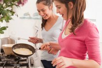 Teenage girls making pancakes — Stock Photo