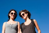 Women smiling together against clear sky — Stock Photo