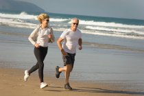 Couple running on a beach — Stock Photo