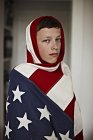 Boy holding American flag indoors — Stock Photo